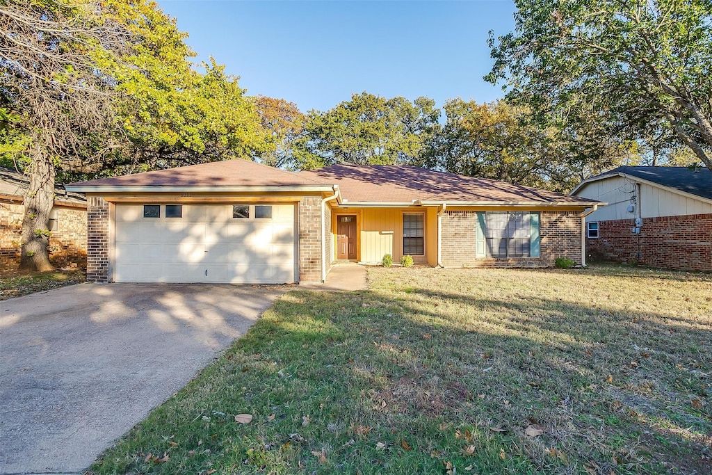 single story home featuring a garage and a front lawn