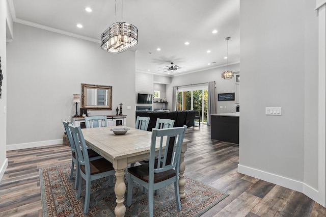 dining room with crown molding, dark wood-type flooring, and ceiling fan with notable chandelier