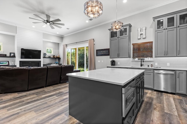 kitchen with sink, gray cabinetry, a center island, stainless steel dishwasher, and pendant lighting