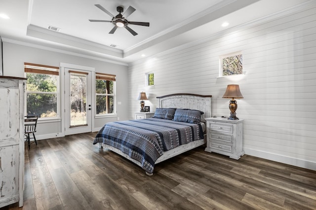 bedroom with crown molding, dark hardwood / wood-style floors, access to outside, and a tray ceiling