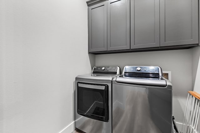 laundry room with washer and clothes dryer and cabinets