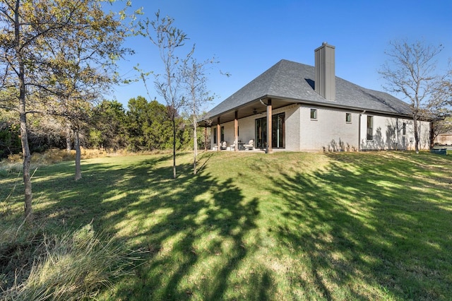 back of property with a lawn and a patio area