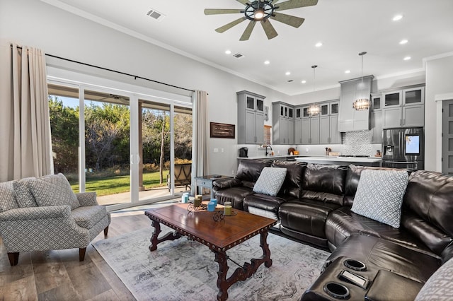 living room with crown molding, hardwood / wood-style floors, and ceiling fan