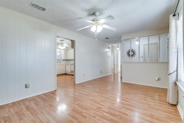 unfurnished room with ceiling fan, light hardwood / wood-style flooring, and a textured ceiling