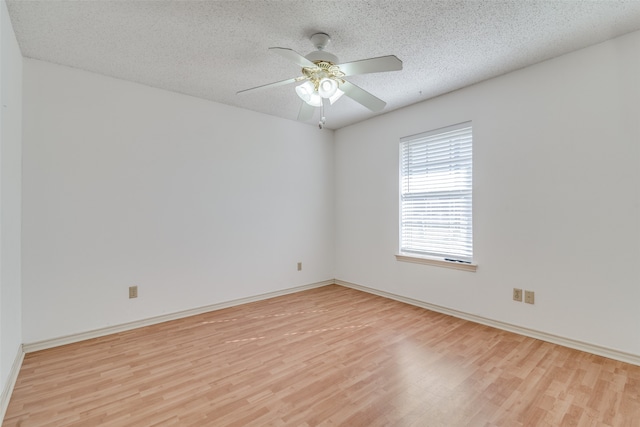 empty room with ceiling fan, a textured ceiling, and light wood-type flooring