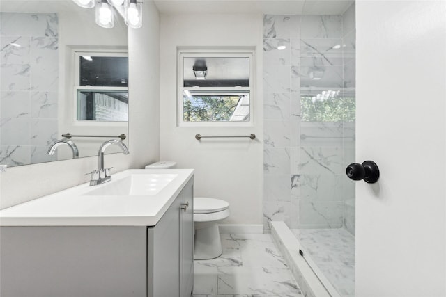 bathroom featuring toilet, vanity, and a tile shower