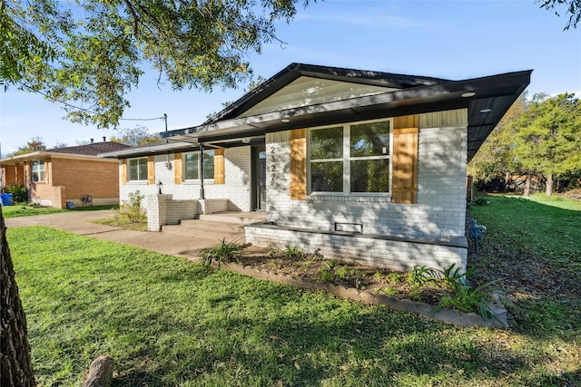 ranch-style house featuring a front yard and a patio area