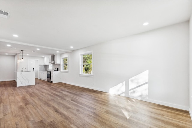 unfurnished living room featuring light hardwood / wood-style flooring and sink