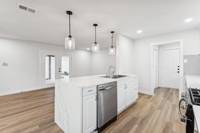 kitchen with appliances with stainless steel finishes, a kitchen island with sink, pendant lighting, white cabinets, and sink