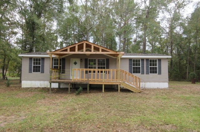 rear view of house with a yard and a deck