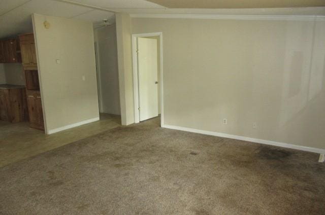 unfurnished room with crown molding and dark colored carpet