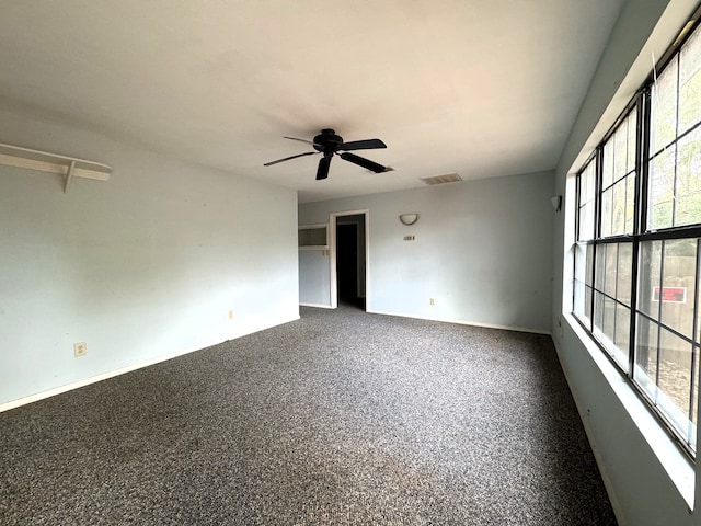 empty room featuring ceiling fan and carpet