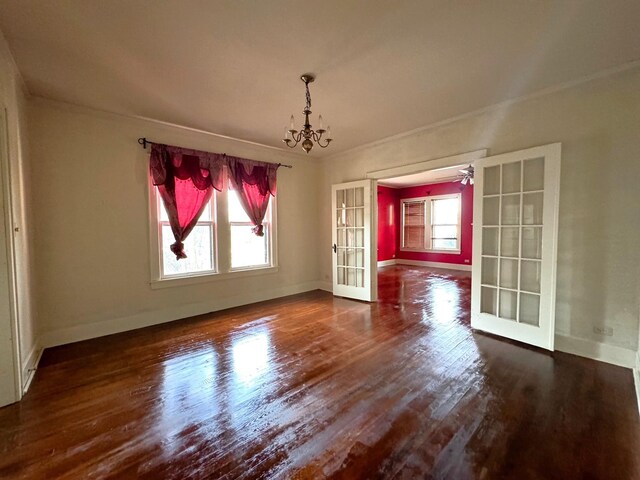 unfurnished dining area featuring french doors, dark hardwood / wood-style flooring, and a notable chandelier