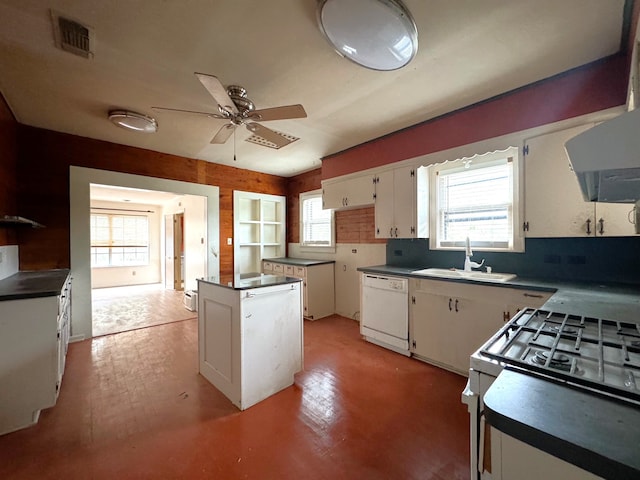 kitchen featuring white cabinetry, sink, a center island, ceiling fan, and white appliances