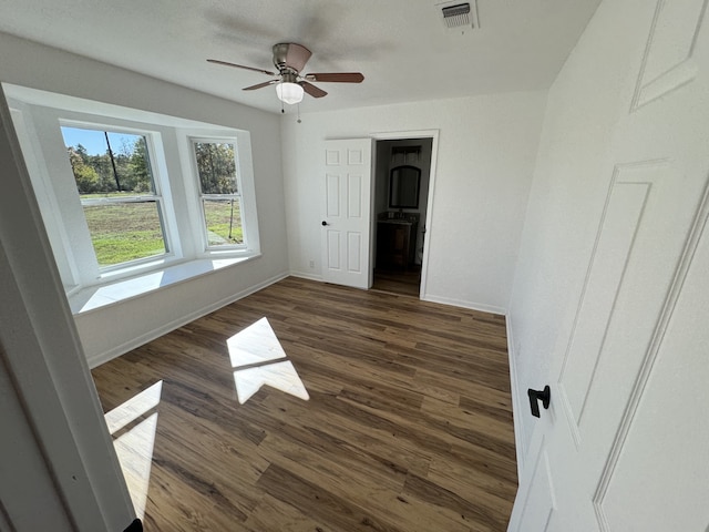 spare room with ceiling fan and dark wood-type flooring