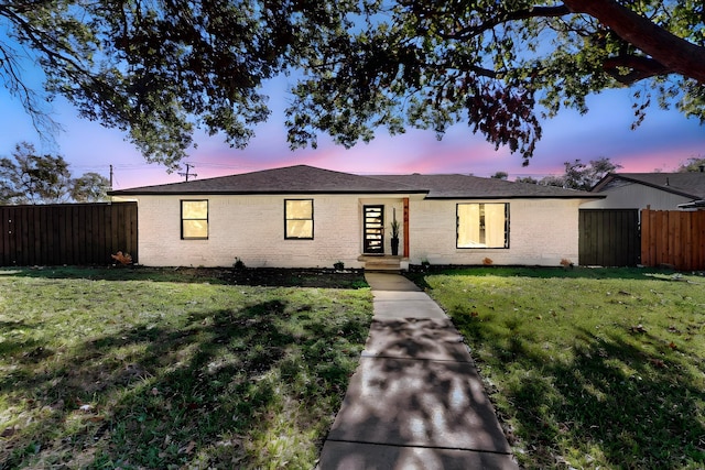 ranch-style home with a yard