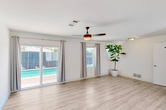 unfurnished room featuring light wood-type flooring, ceiling fan, and a healthy amount of sunlight