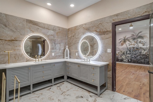 bathroom with wood-type flooring, vanity, and tile walls