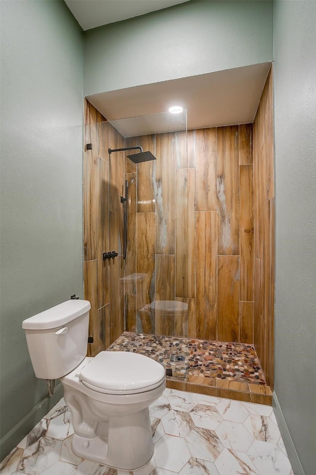 bathroom featuring tiled shower and toilet