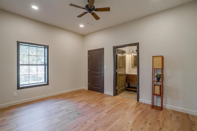 unfurnished bedroom with light wood-type flooring, connected bathroom, and ceiling fan