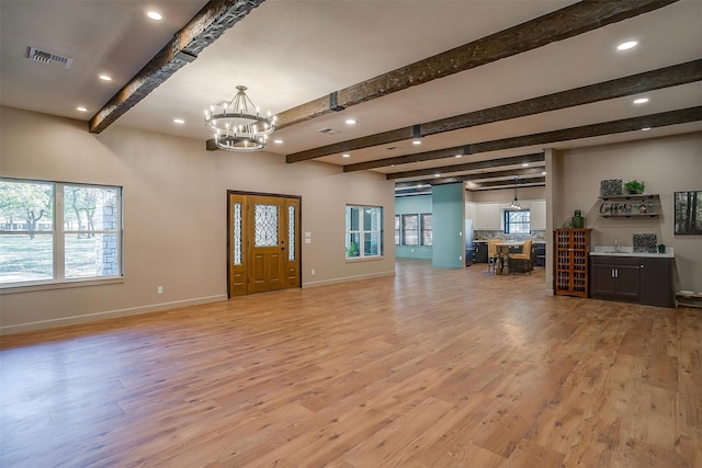 foyer featuring plenty of natural light, beam ceiling, and light wood-type flooring