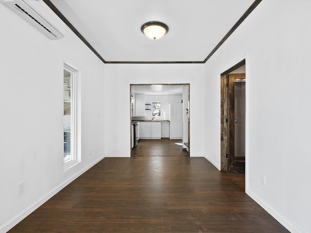 hall with ornamental molding, a wall unit AC, and dark wood-type flooring