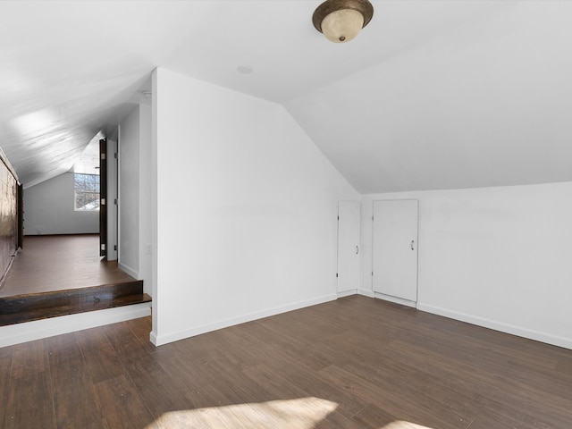 additional living space featuring dark hardwood / wood-style flooring and vaulted ceiling