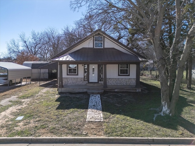 bungalow-style home with a carport, a porch, and a front lawn