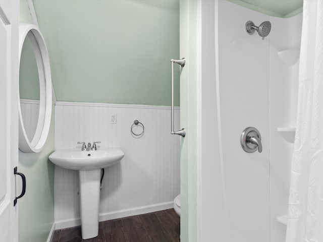 bathroom featuring hardwood / wood-style flooring, a shower with curtain, sink, and toilet