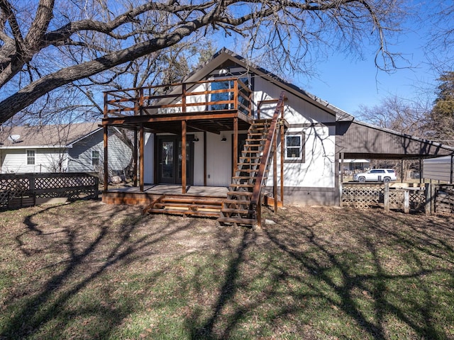 rear view of property featuring a yard, a carport, and a deck