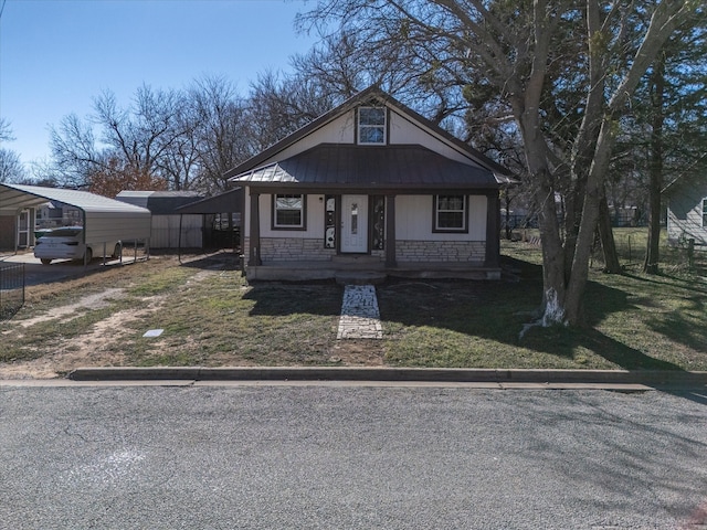 bungalow with a front yard, a porch, and a carport