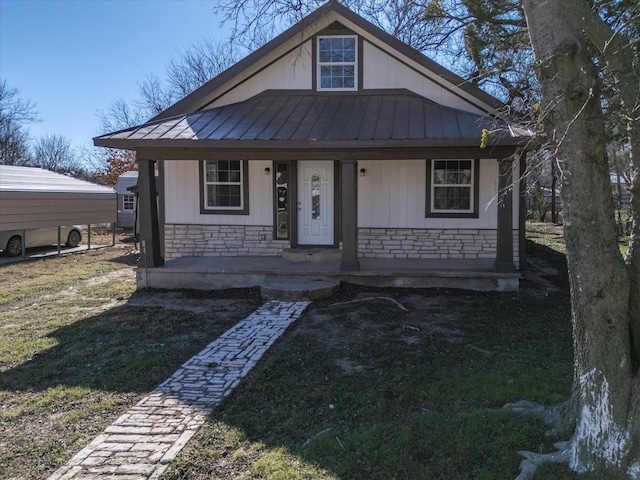 bungalow-style home with a front lawn and covered porch