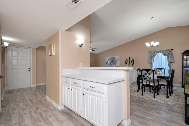 kitchen featuring pendant lighting, light countertops, visible vents, white cabinets, and a chandelier