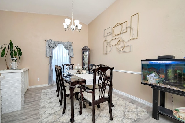 dining room with baseboards, an inviting chandelier, lofted ceiling, and light wood-style floors