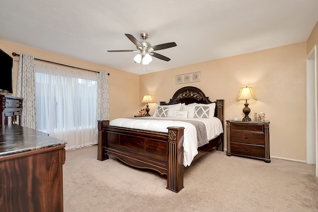 bedroom with light colored carpet, ceiling fan, and baseboards