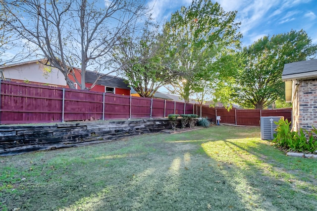 view of yard featuring a fenced backyard and central AC