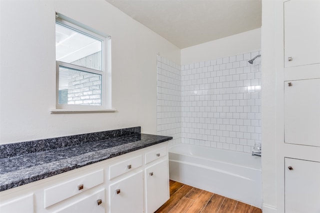 bathroom featuring tiled shower / bath, wood-type flooring, and vanity