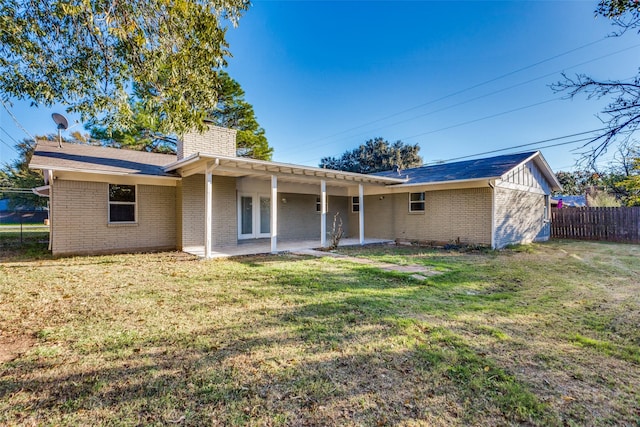 rear view of property with a lawn and a patio area