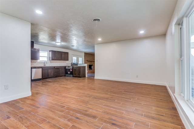 unfurnished living room featuring sink and light hardwood / wood-style floors