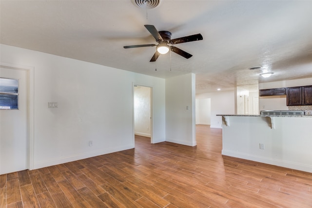 unfurnished living room with wood-type flooring and ceiling fan