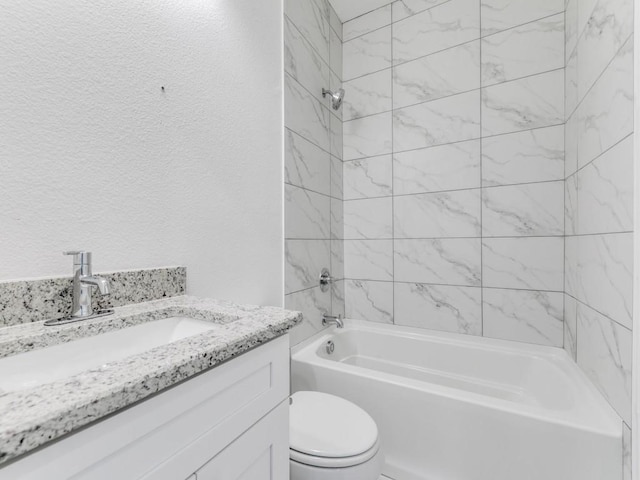 full bathroom with vanity, tiled shower / bath combo, and toilet