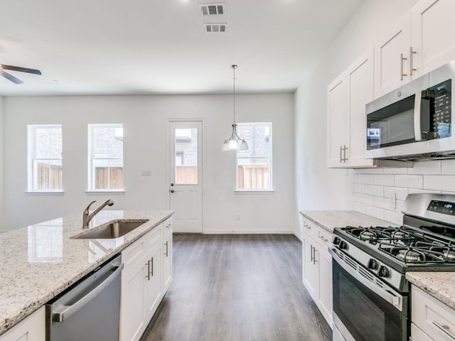 kitchen with white cabinetry, appliances with stainless steel finishes, sink, and light stone counters