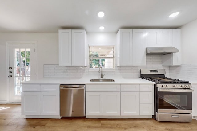 kitchen featuring sink, white cabinets, exhaust hood, and appliances with stainless steel finishes