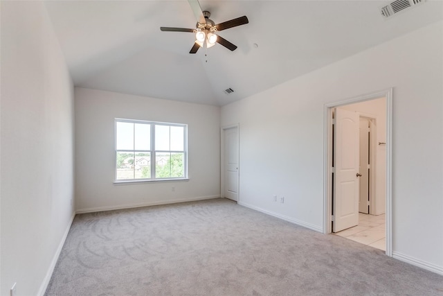 empty room featuring ceiling fan, lofted ceiling, and light carpet