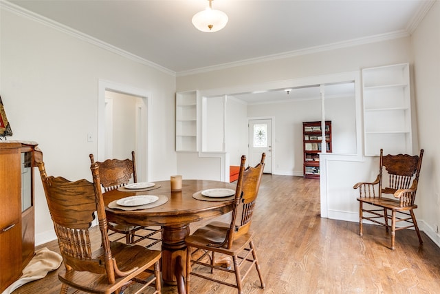 dining space with hardwood / wood-style floors and ornamental molding