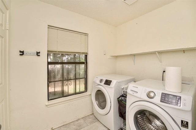 laundry room featuring light tile patterned flooring and washing machine and clothes dryer