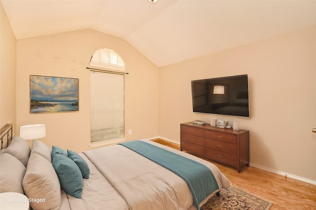 bedroom featuring light wood-type flooring and lofted ceiling