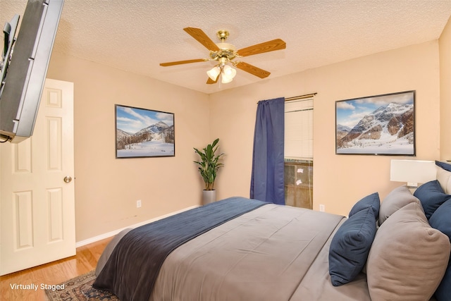 bedroom featuring ceiling fan, wood-type flooring, and a textured ceiling