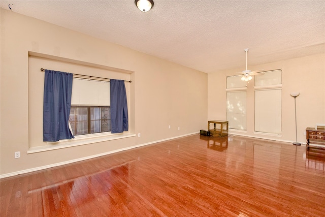 unfurnished living room with hardwood / wood-style floors, a textured ceiling, and ceiling fan