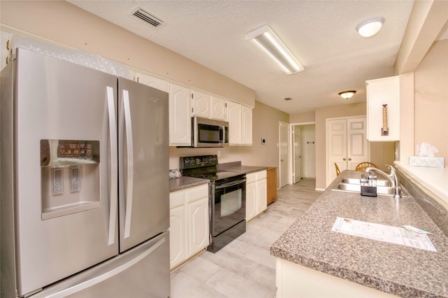 kitchen with white cabinetry, sink, stainless steel appliances, and a textured ceiling